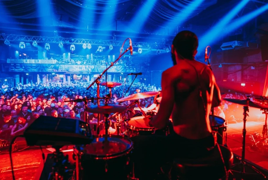 A bands drummer playing on stage in from of the radar festival crowd
